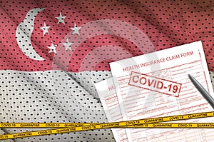 Singapore flag and Health insurance claim form with covid-19 stamp. Coronavirus or 2019-nCov virus concept