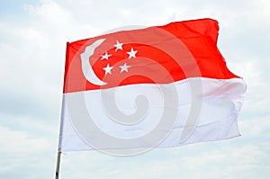 The Singapore flag with red white horizontal bands crescent moon and five stars flying