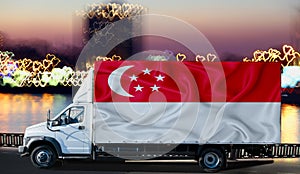 Singapore flag on the side of a white van against the backdrop of a blurred city and river. Logistics concept