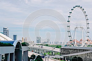 Cars traffic on Sheares ave with Singapore Flyer giant ferris wheel on background