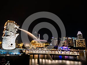 SINGAPORE - NOV 22, 2018: The Merlion fountain spouts water in front of the Marina Bay Sands hotel in Singapore. This fountain is