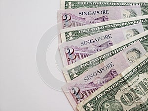 Singaporean banknotes of two dollars and American one dollar bills