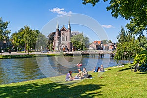 Singelgracht with church and relaxing people, Alkmaar, Netherlan