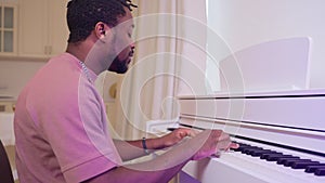 singer or composer playing beautiful melody by piano, african american man sitting at synthesizer