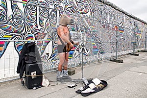 Singer in front of East side gallery. Berlin wall., Germany