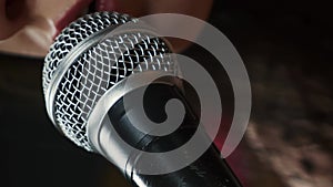 Singer performing song into microphone at music studio, close up. Vertical video