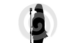 Singer singing in front of a retro microphone. White. Silhouette