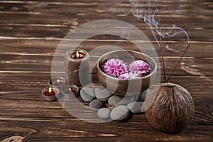 Singing bowl with candles with pebbles on dark wooden background