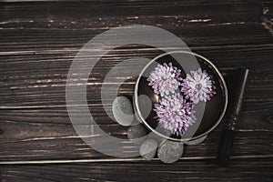 Singing bowl with candles with pebbles on dark wooden background