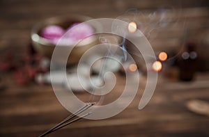 Singing bowl with candles with pebbles on dark wooden background