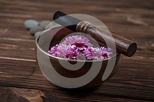 Singing bowl with candles with pebbles on dark wooden background