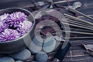 Singing bowl with candles with pebbles on dark wooden background