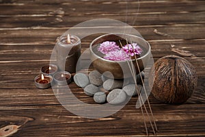 Singing bowl with candles with pebbles on dark wooden background