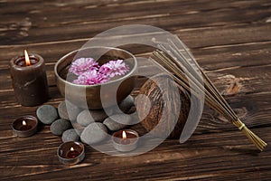 Singing bowl with candles with pebbles on dark wooden background