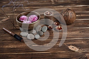 Singing bowl with candles with pebbles on dark wooden background