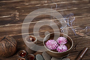 Singing bowl with candles with pebbles on dark wooden background