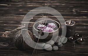 Singing bowl with candles with pebbles on dark wooden background