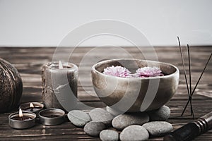 Singing bowl with candles with pebbles on dark wooden background