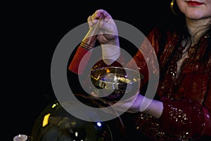 A singing cup in the hands of a clairvoyant in a magic salon on a black background.