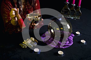 A singing cup in the hands of a clairvoyant in a magic salon on a black background.