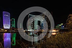 Singing light and music fountain on background of panorama of beautiful buildings at night