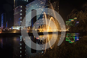 Singing light and music fountain on background of panorama of beautiful buildings at night