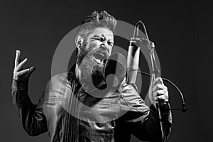 Singing man in a recording studio. Expressive bearded man with microphone. Expressive singer with microphone.