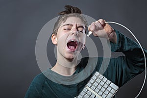 Singing teenage boy with computer keyboard