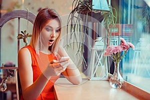 Single amazed girl watching content on a smart phone at home