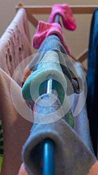 Single ankle sock mismatched with sock pairs drying on laundry rack after washing. Depicting missing socks, sock pairs, laundry