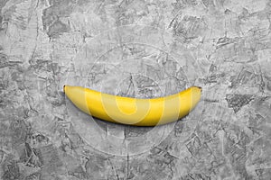 Single banana on gray concrete texture background