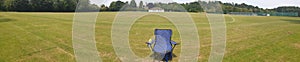 Single beach chair in an empty playing field on a summers day