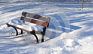 Single bench covered with snow in winter park