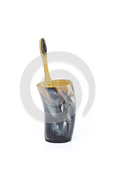 A single Biodegradable bamboo toothbrush in a horn beaker isolated on a  white background