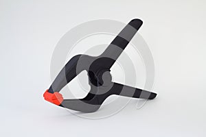 Single black plastic spring clamp  over white background