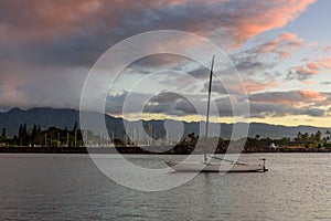 Single boat, in a calm sea, at sunset on the north shore of Oahu, Hawaii.