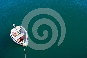 Single boat floating on blue-green sea