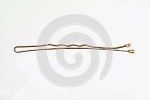 Single brass hair pin horizontal macro shot isolated on white background