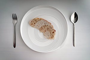 Single Bread served on white table in a gloomy mood