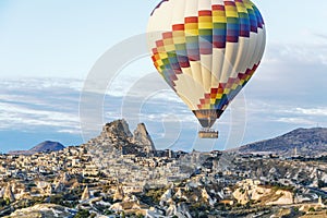 Beautiful bright hot air balloon floats above town in Cappadoccia, Turkey photo