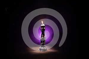 Single burning candle. Light of flame and flowing candle wax, dark background