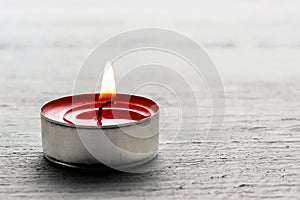 Single burning red tealight candle