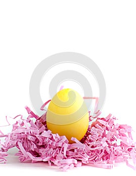 Single Canary-Yellow Easter Egg in a Nest of Pink Confetti.
