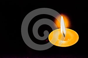 A single candle with bright flames in a dark background