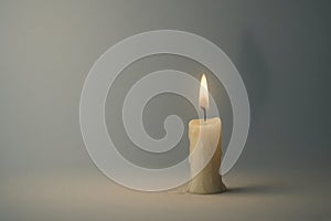 A single candle burns in silence. Space for text.