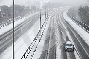 Single Car On Motorway During Snow Storm