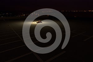 A single car in a parking lot representing the concept of working late