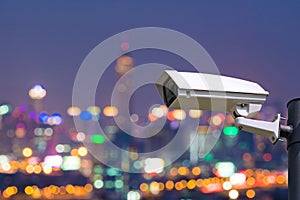 Single CCTV Security camera on Blurred night downtown city