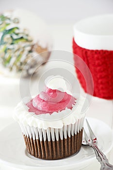 Single Christmas homemade chocolate cupcake with frosting white pink buttercream.
