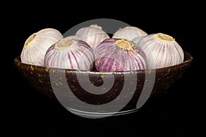 Single clove garlic isolated on black glass